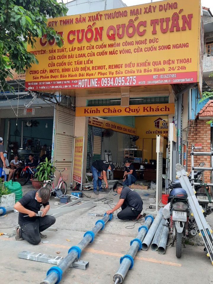 Thợ Quốc Tuấn gia công ống trục cửa cuốn trước cửa hàng Cửa Cuốn Quốc Tuấn